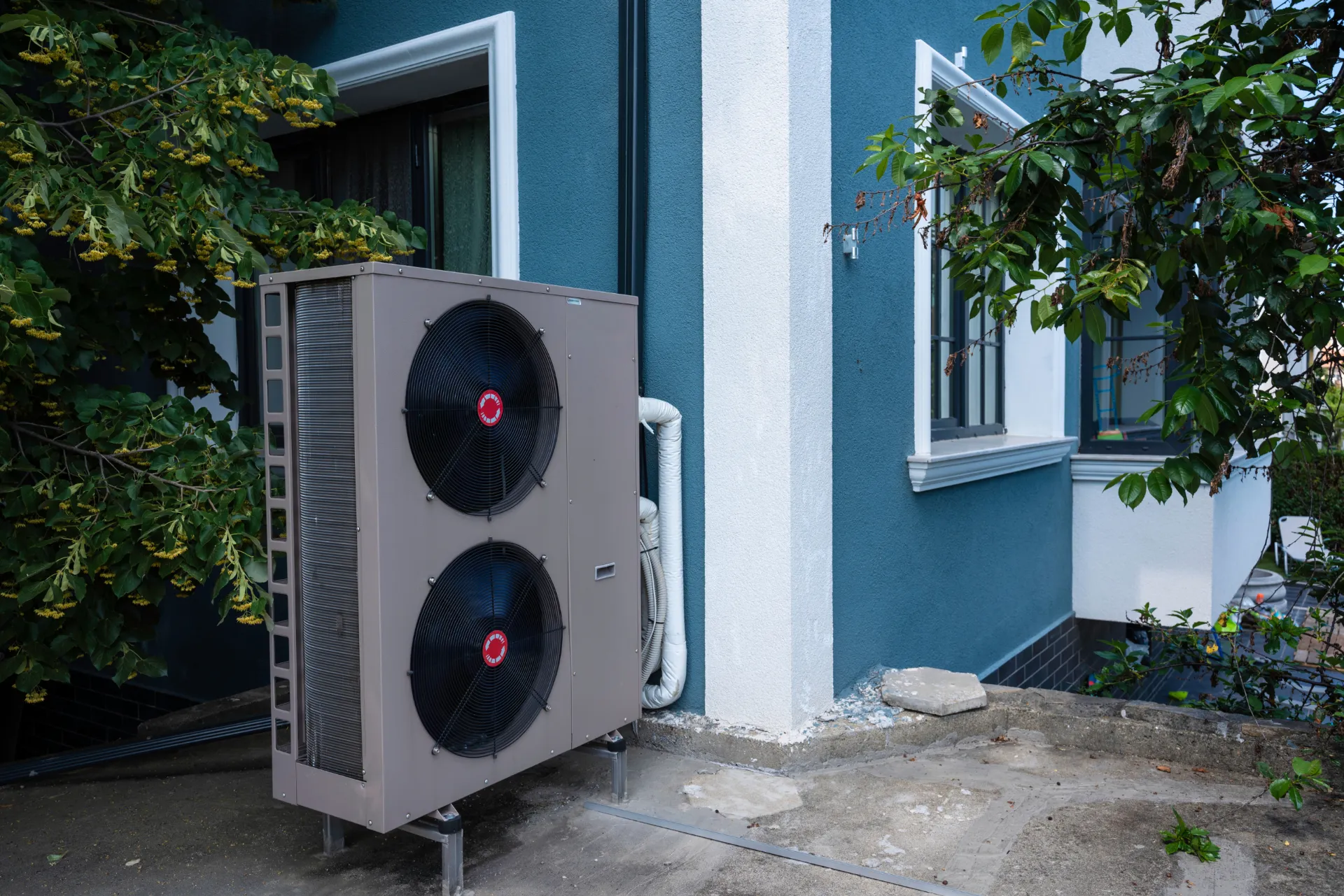 Eine außen aufgestellte Wärmepumpe im hinterhof.