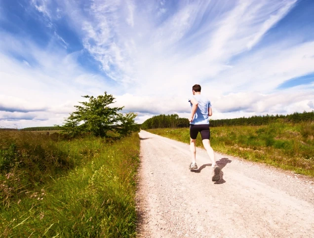 A man running outdoors to improve microbiome health with exercise