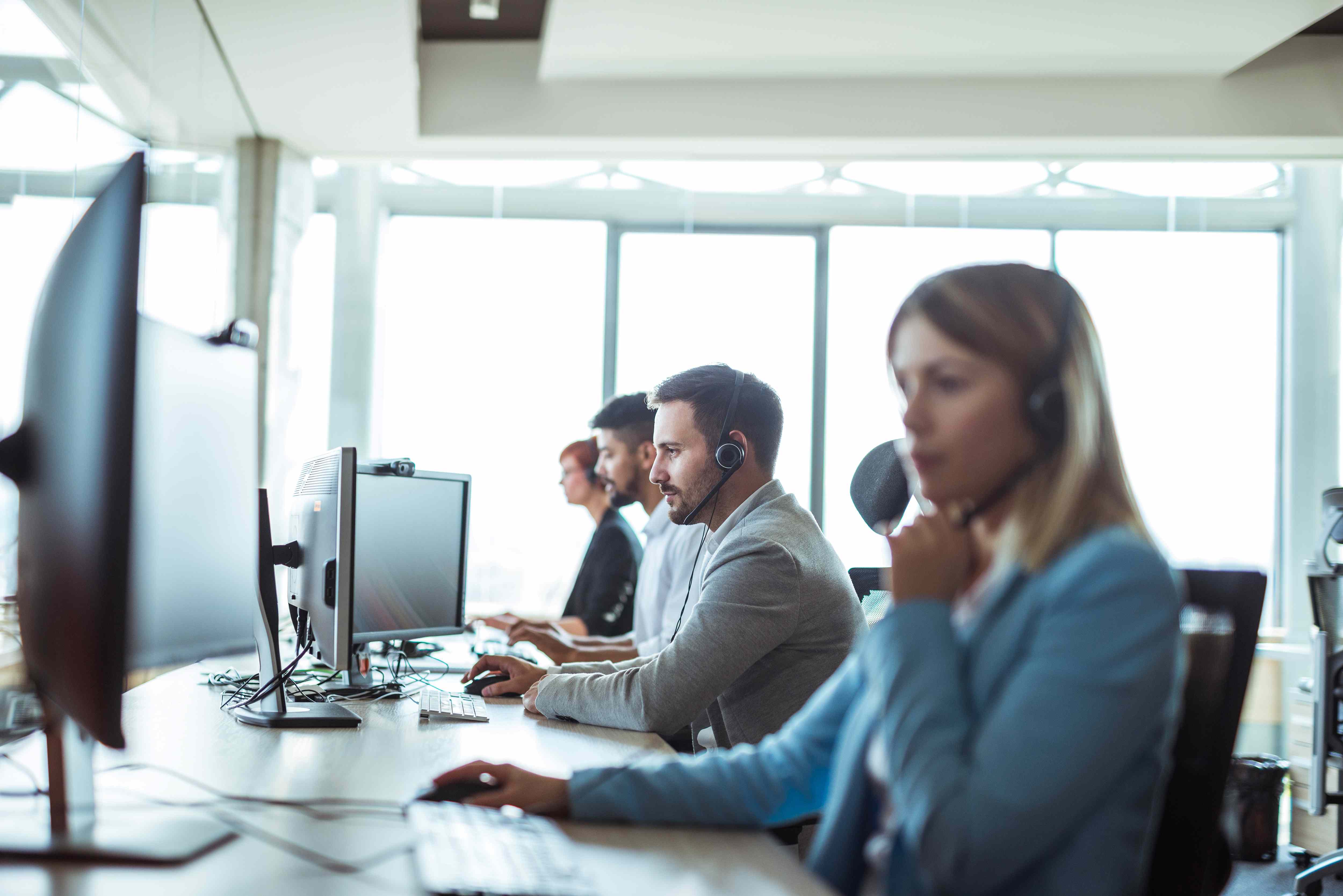 Busy BPO office space with employees engaged in customer service, showcasing a modern business process outsourcing environment focused on operational excellence