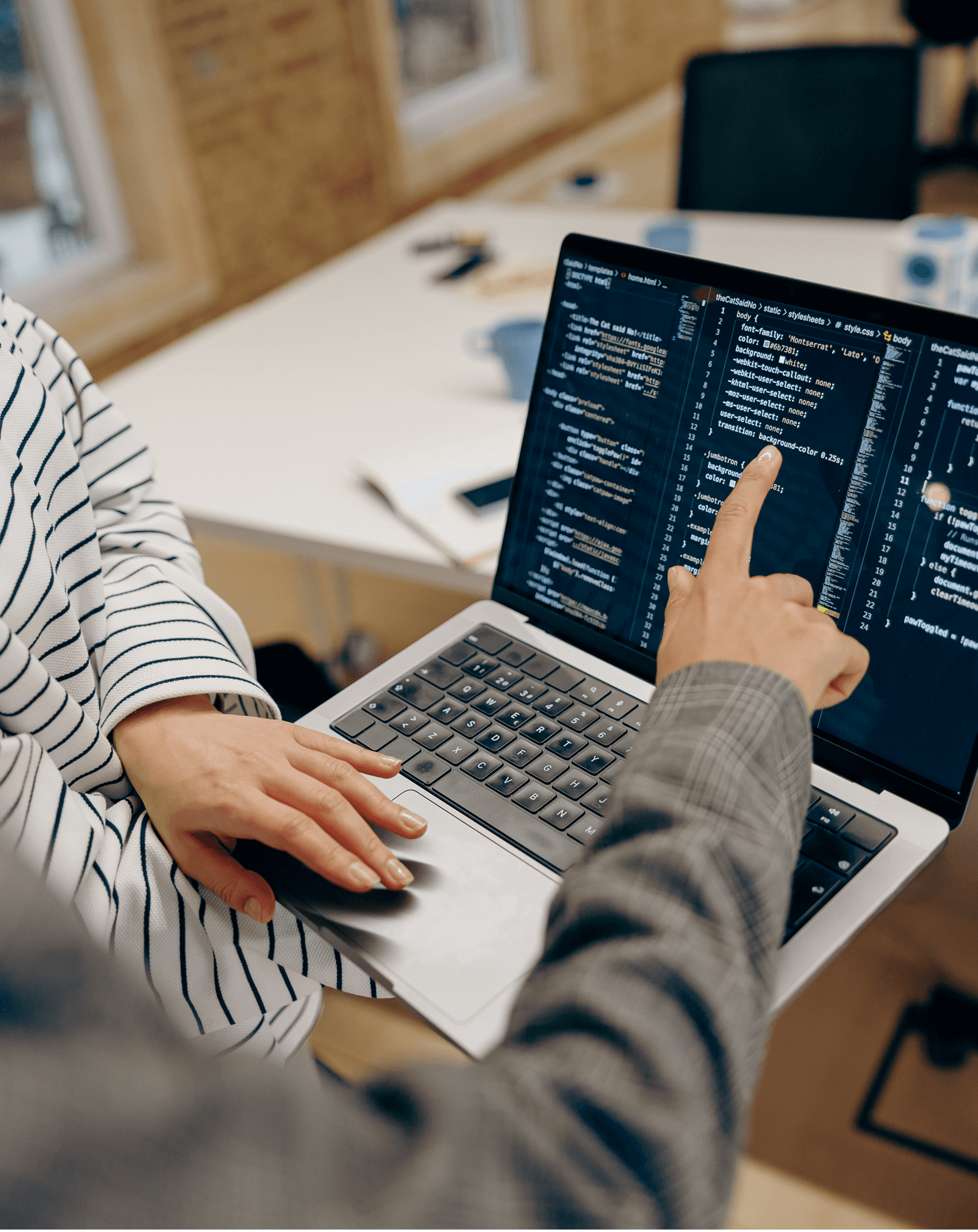 Developers working together on source code in a modern office, highlighting teamwork in software engineering.