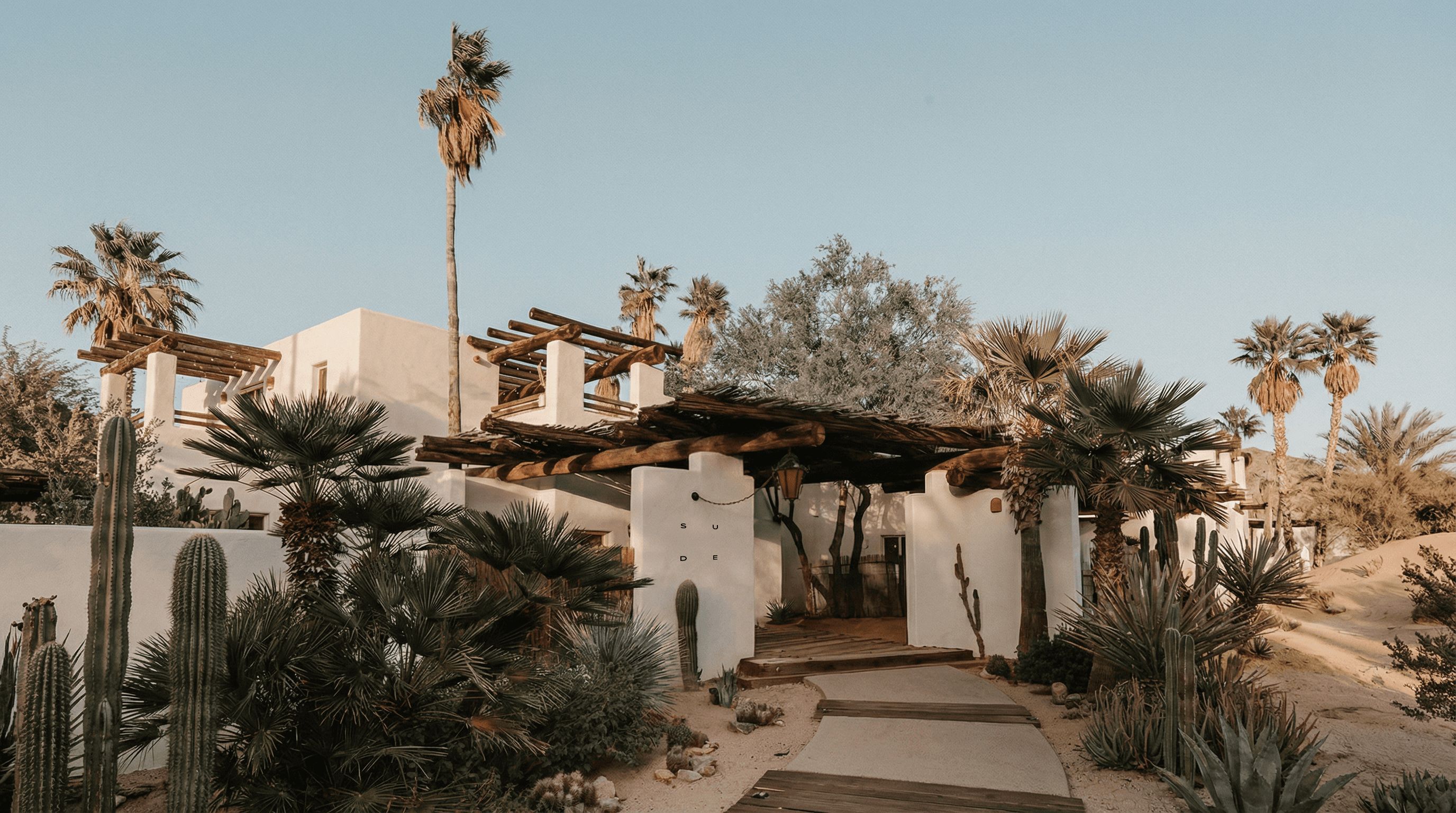 A blank white card resting on a softly draped rust-colored fabric atop a beige quilted surface.