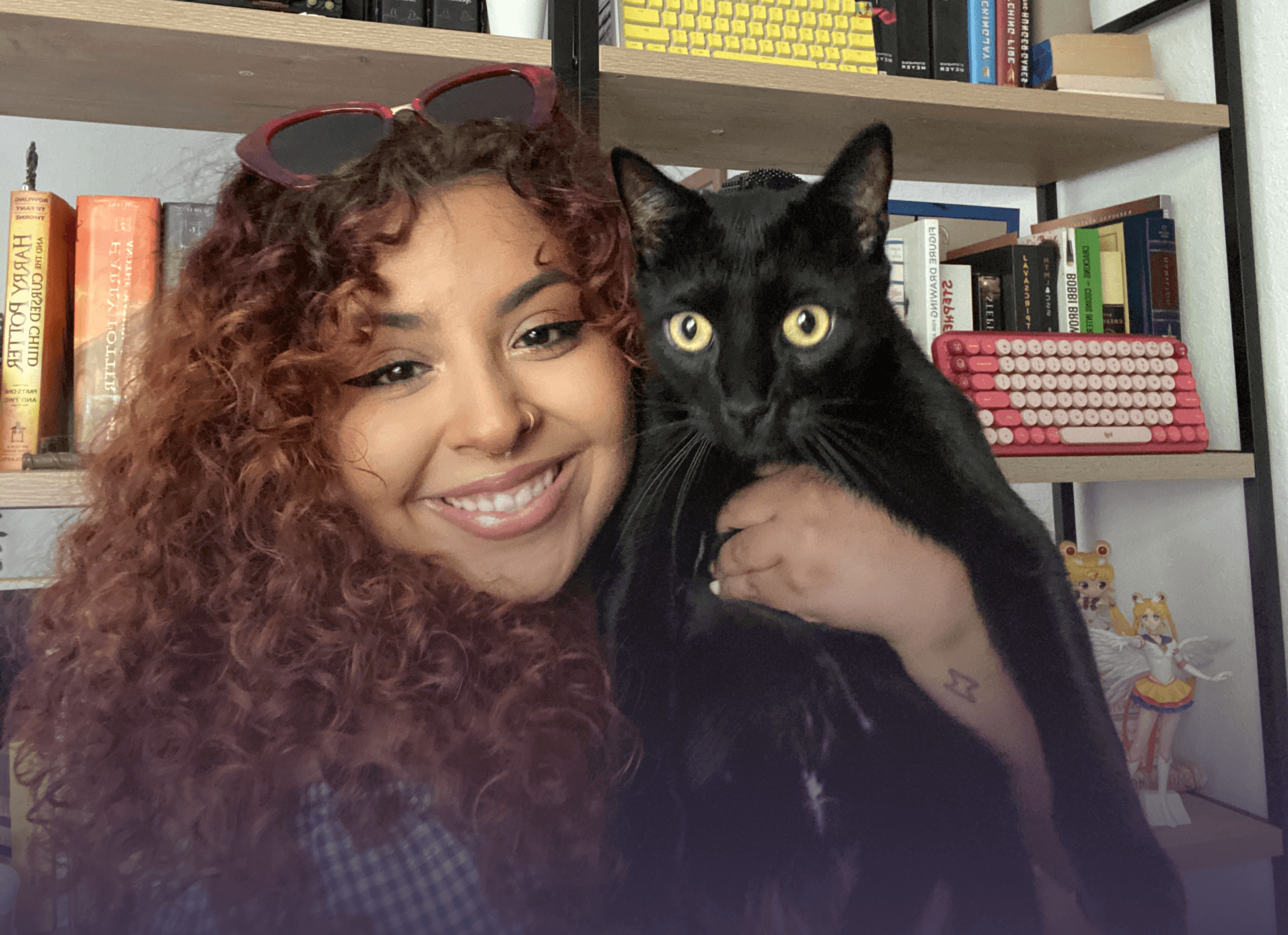 Woman smiling with brown hair holding a black cat