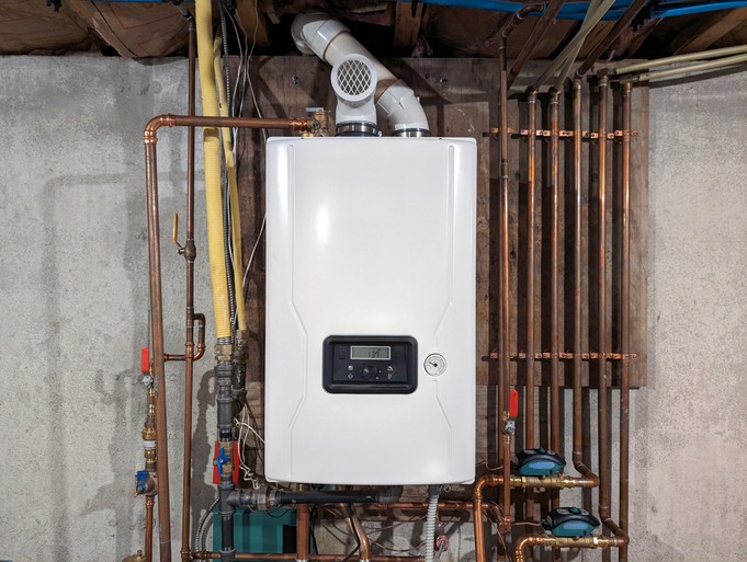 Tankless water heater mounted on a wall inside of a Toronto home basement