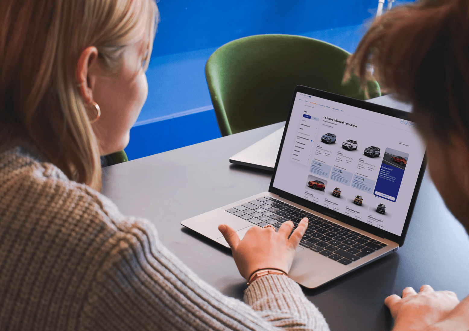 Due persone osservano insieme da un PC le offerte di auto nuove disponibili