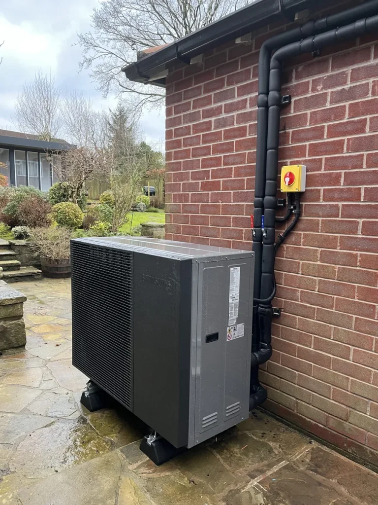 Heat pump installer and colleague reviewing a system report to refer a homeowner for independent technical support