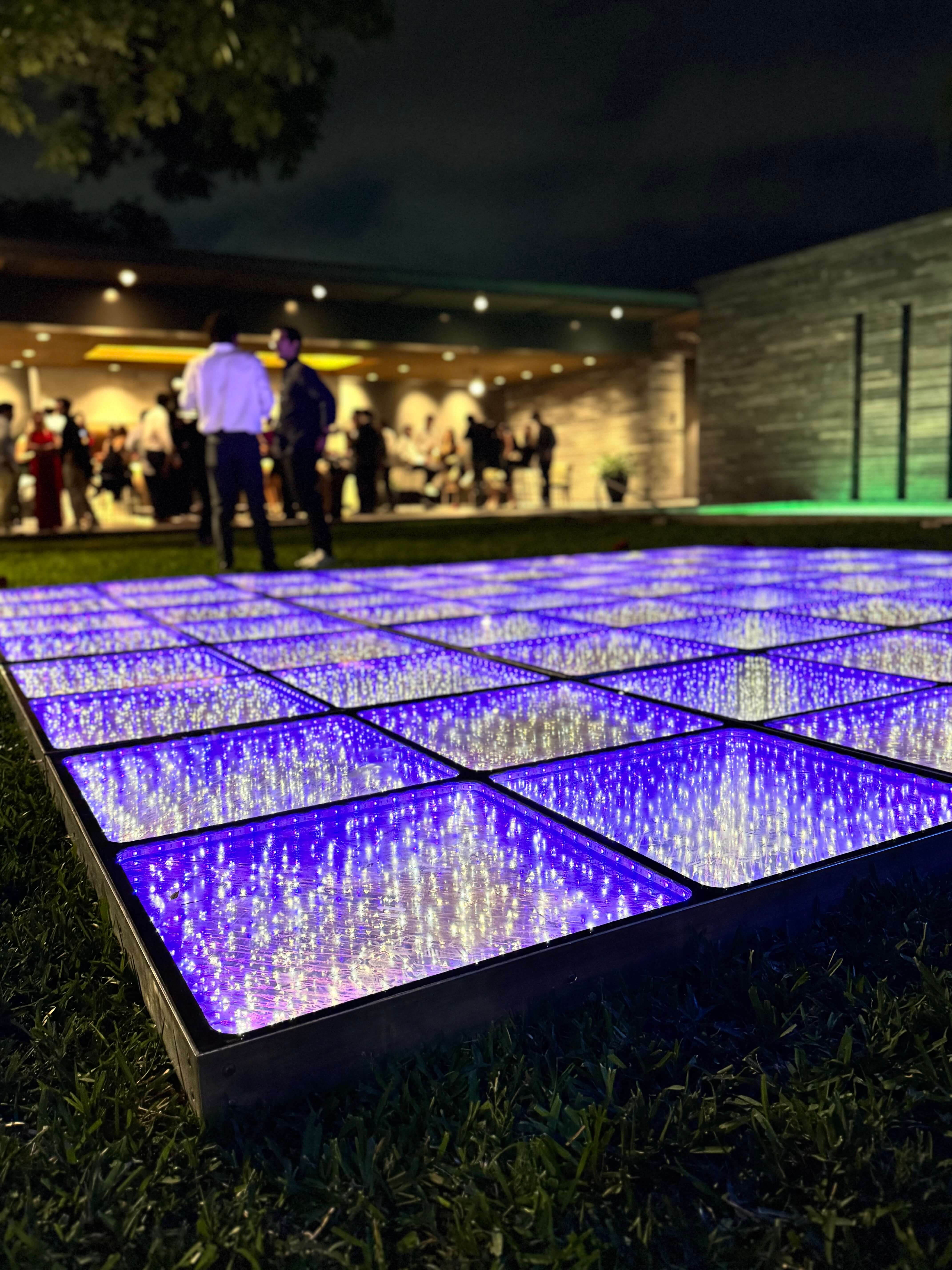 a row of shots in glass, with a background neon sign that says groovy shots