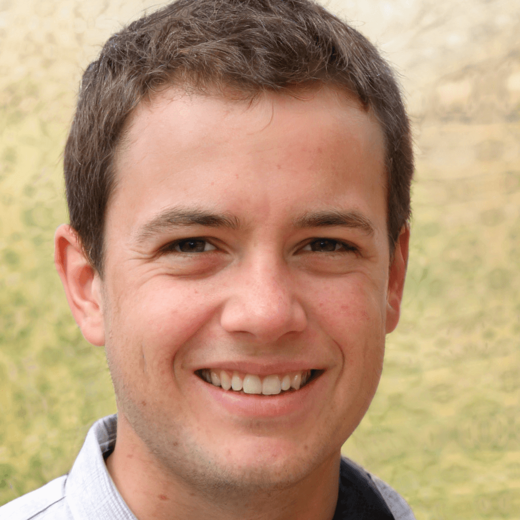 a young man wearing glasses standing in front of a mountain