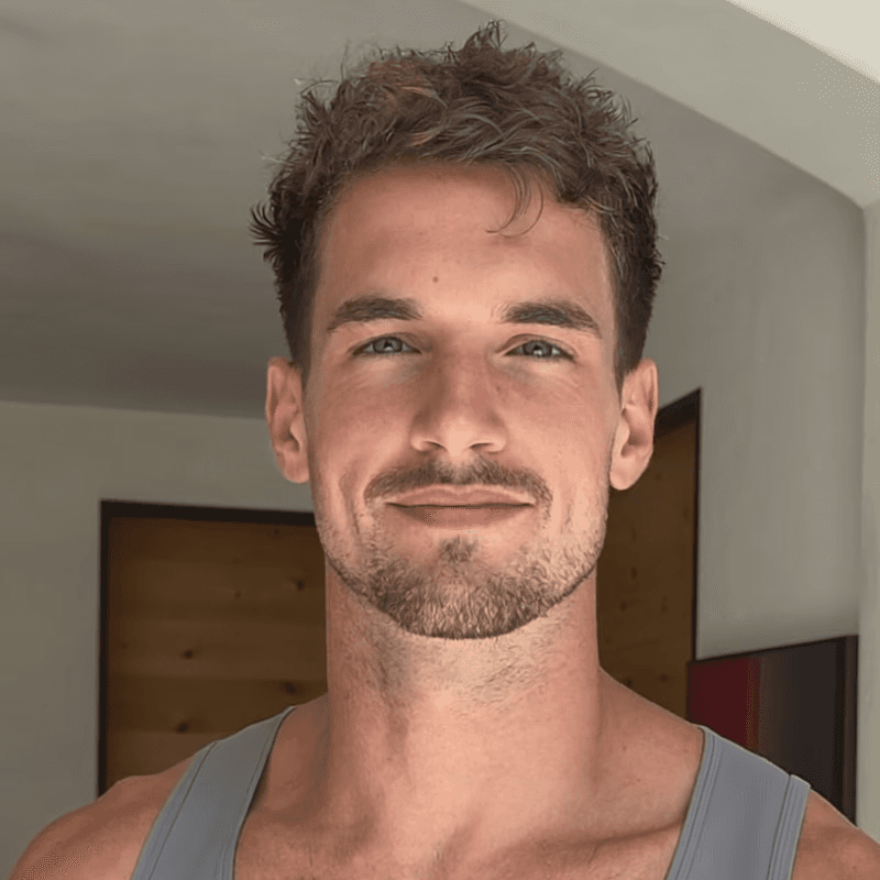 a man with a goatee smiles at the camera