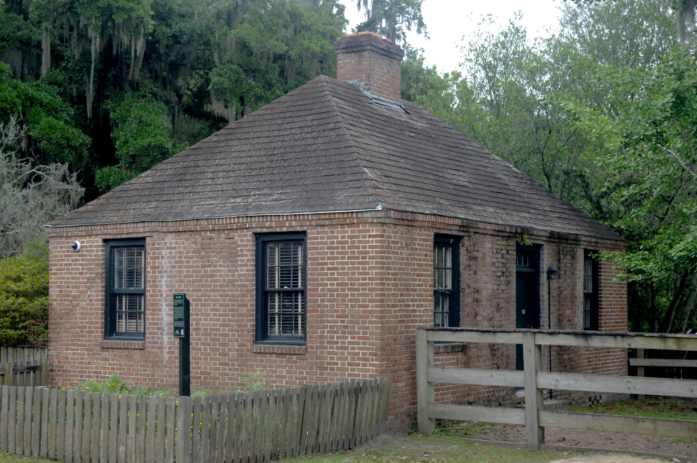 After: the small brick house under the trees, now on a bond