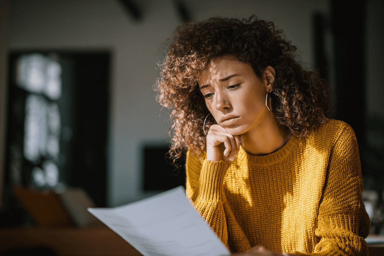 Frau Anfang 40 betrachtet Laborergebnisse am Küchentisch