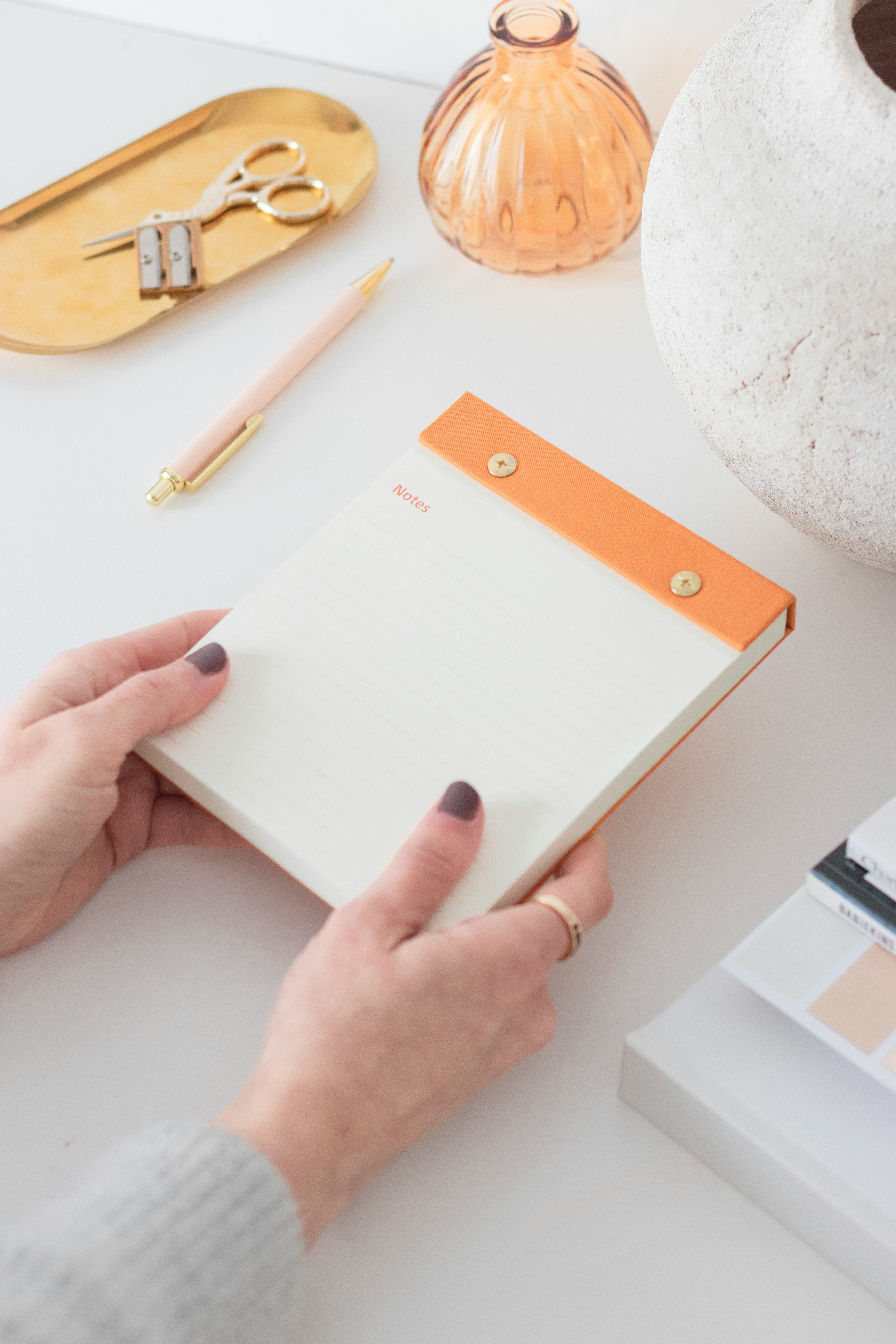 a woman is holding a notepad in her hand