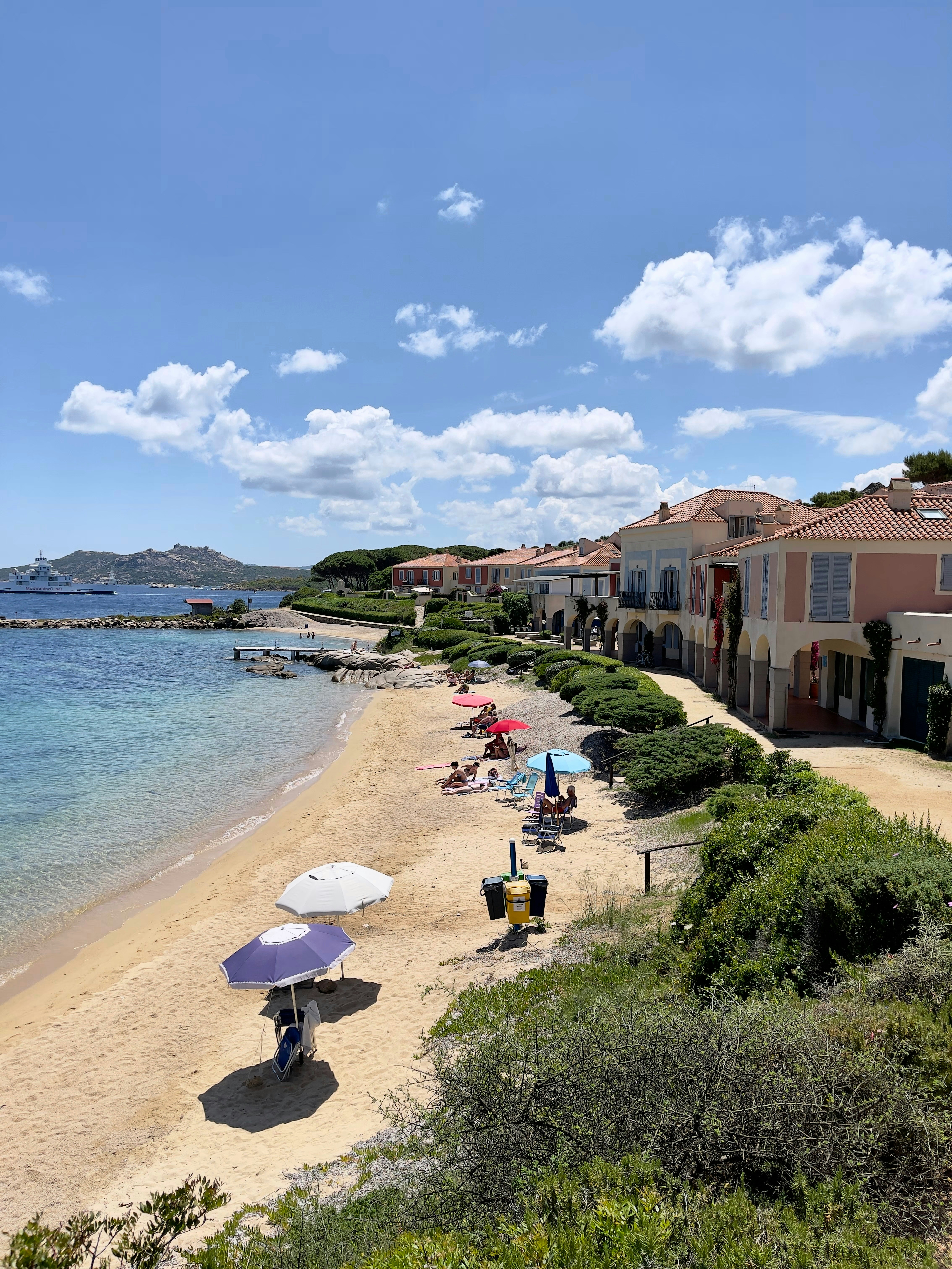 A beach with a few umbrellas and people on it
