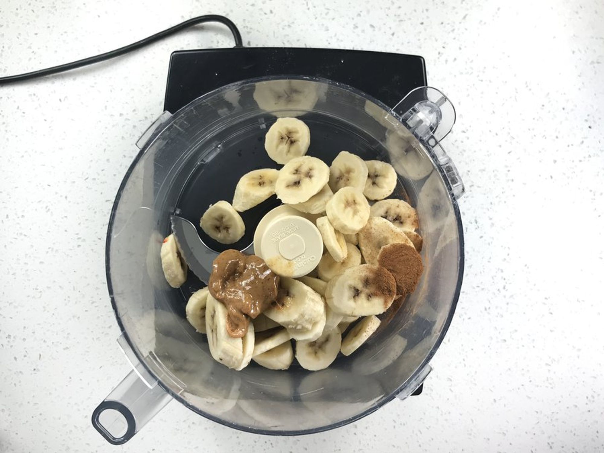 sliced banana and almond butter in a food processor