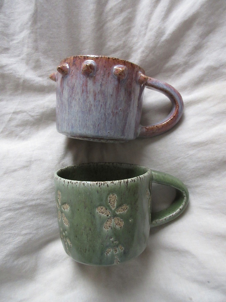 Pink and purple glazed ceramic mug with drip detail and green mug under it