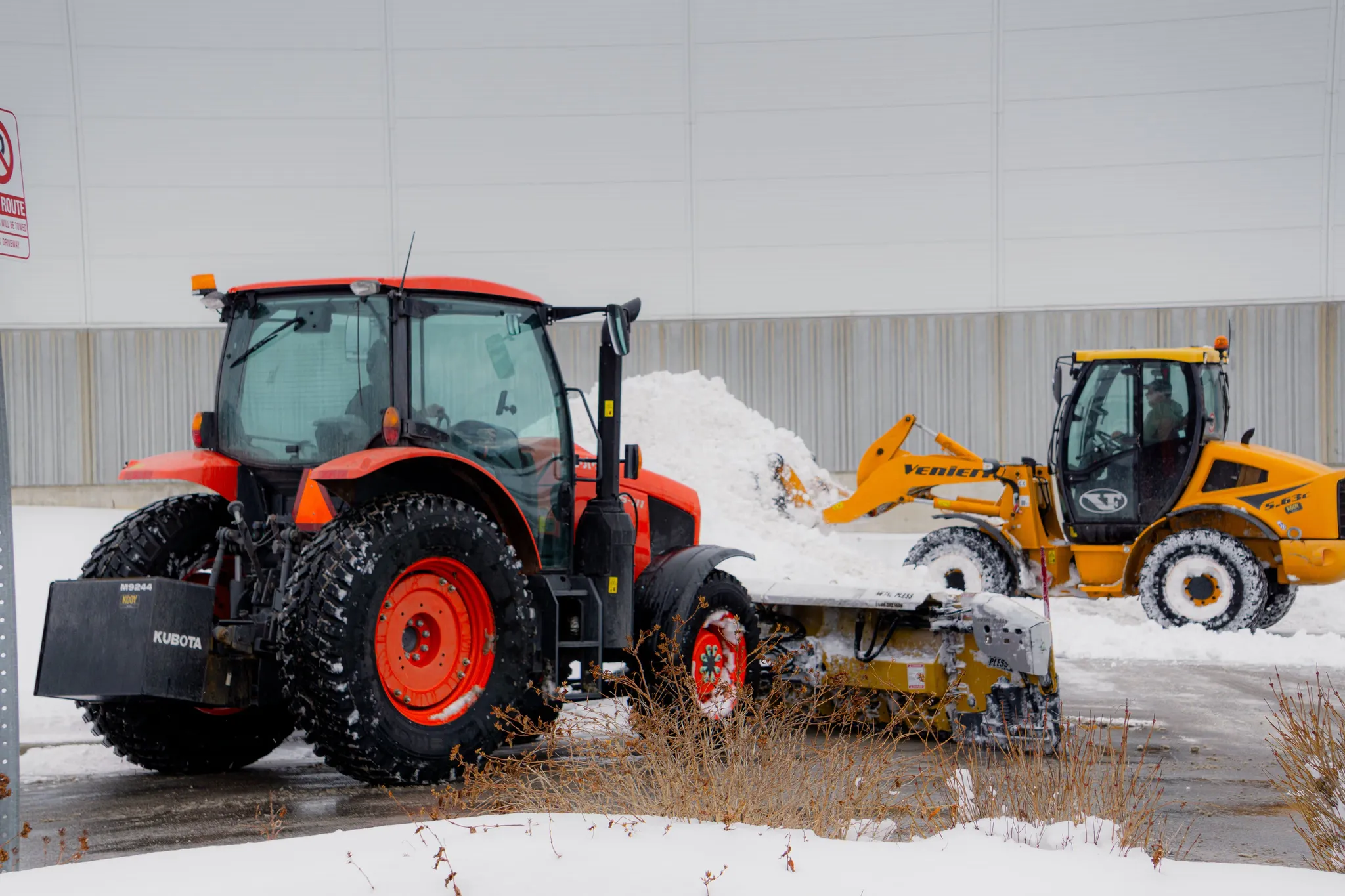 Falcons Landscaping snow removal tractors clearing snow in a commercial parking lot
