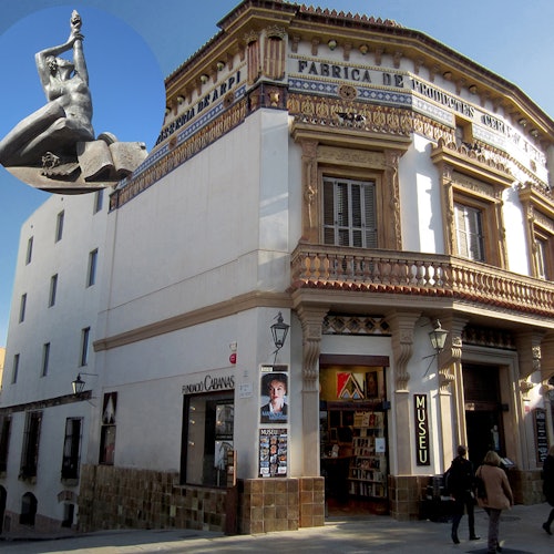 角落建筑带有华丽的外立面，书店入口标有“MUSEU”，两人正在走过。插图：一座雕像的特写。