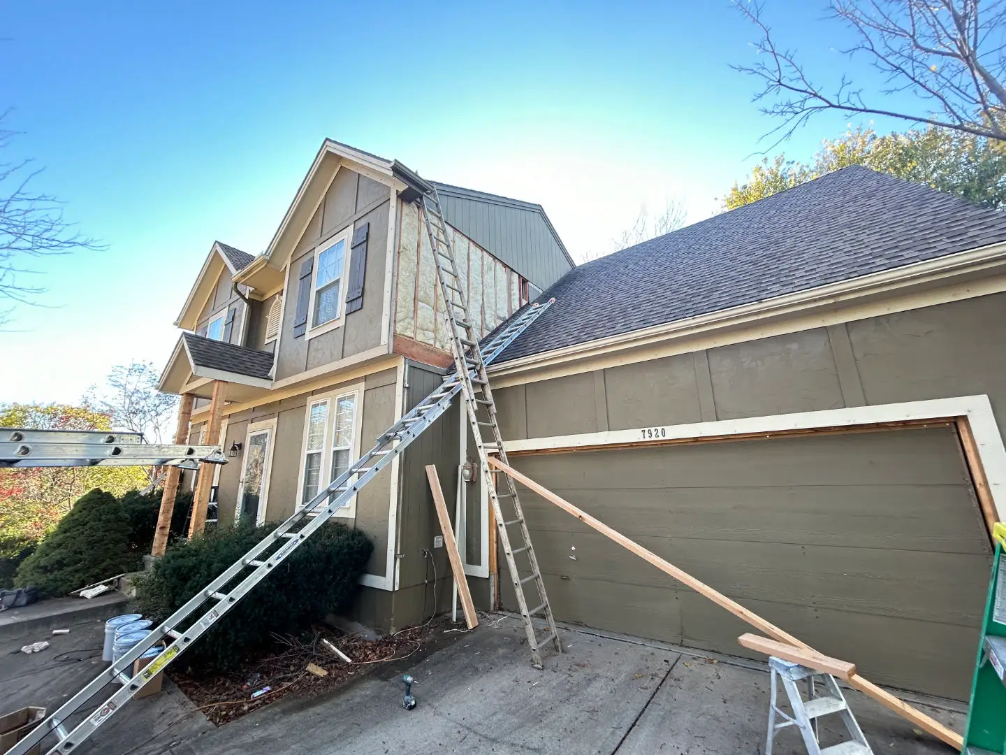 An image of a wood rot being repaired on brown house with white trim.