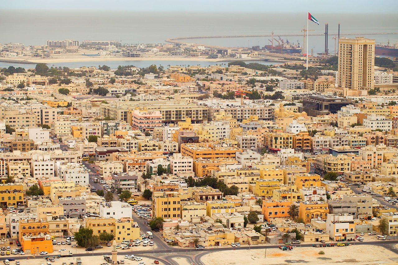 Beautiful Pearl Jumeirah beach showcasing gentle waves, sandy shores, and vibrant palm trees against a sunny backdrop.