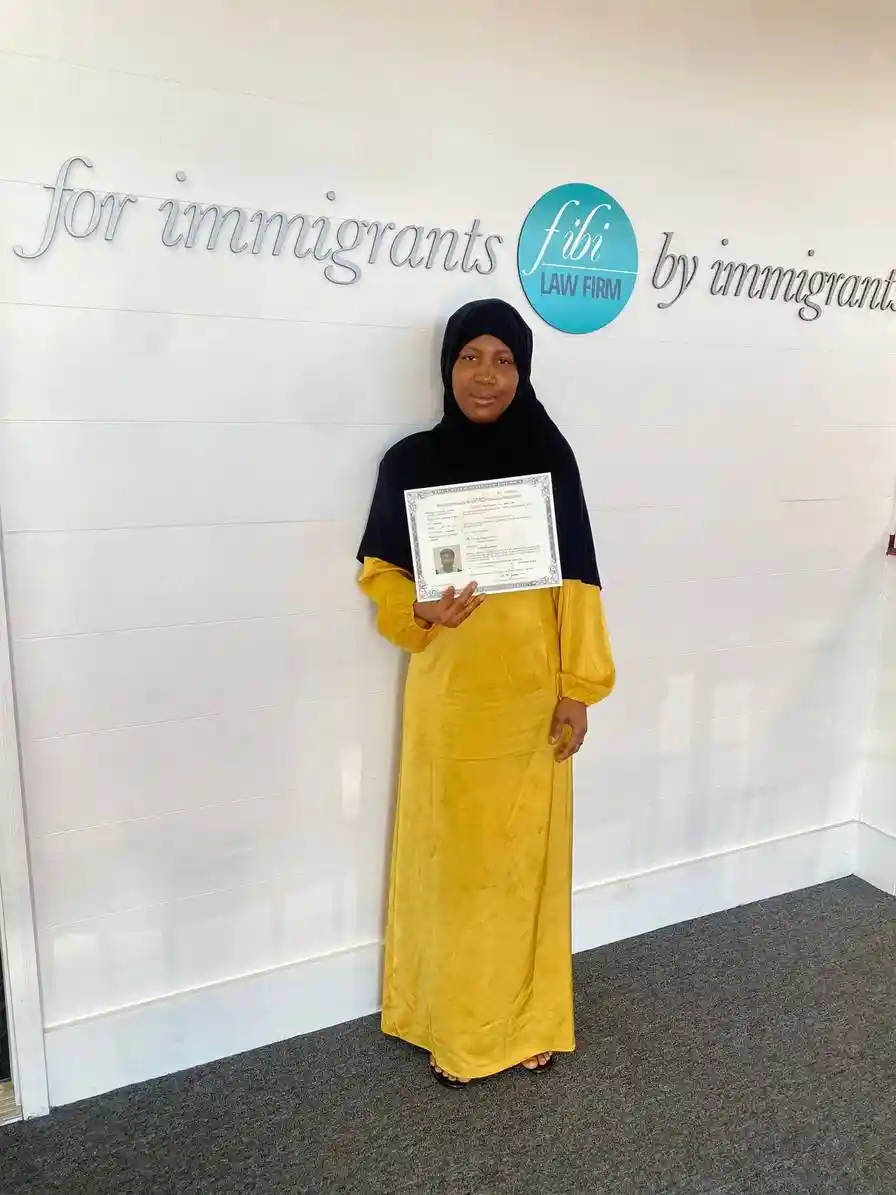 Cheerful young woman with work permit, assisted by Fibi Law