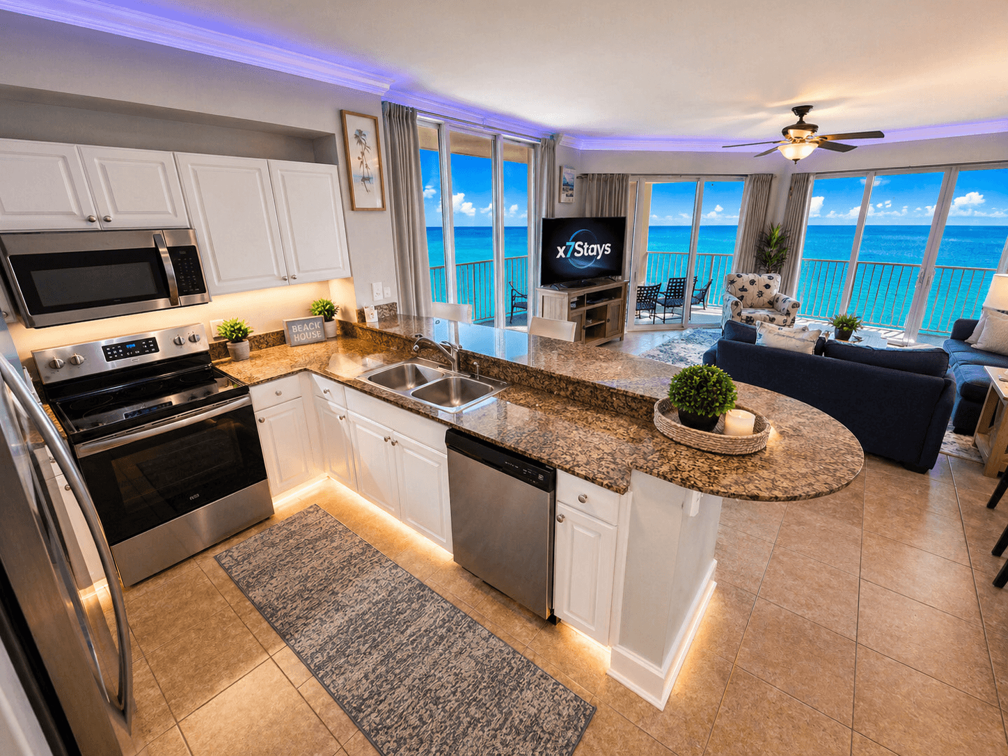 Florida condo kitchen and living room with ocean views and X7 Stays on the TV