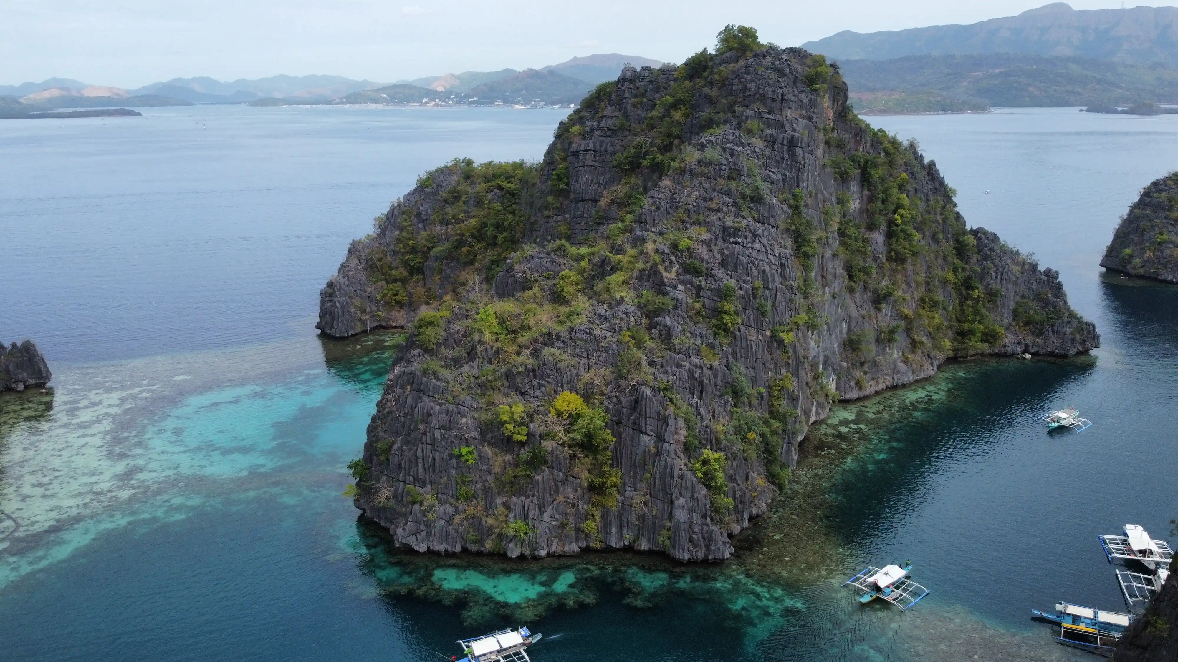 luchtfoto van kalksteenrotsen in helder blauw water in coron, filipijnen