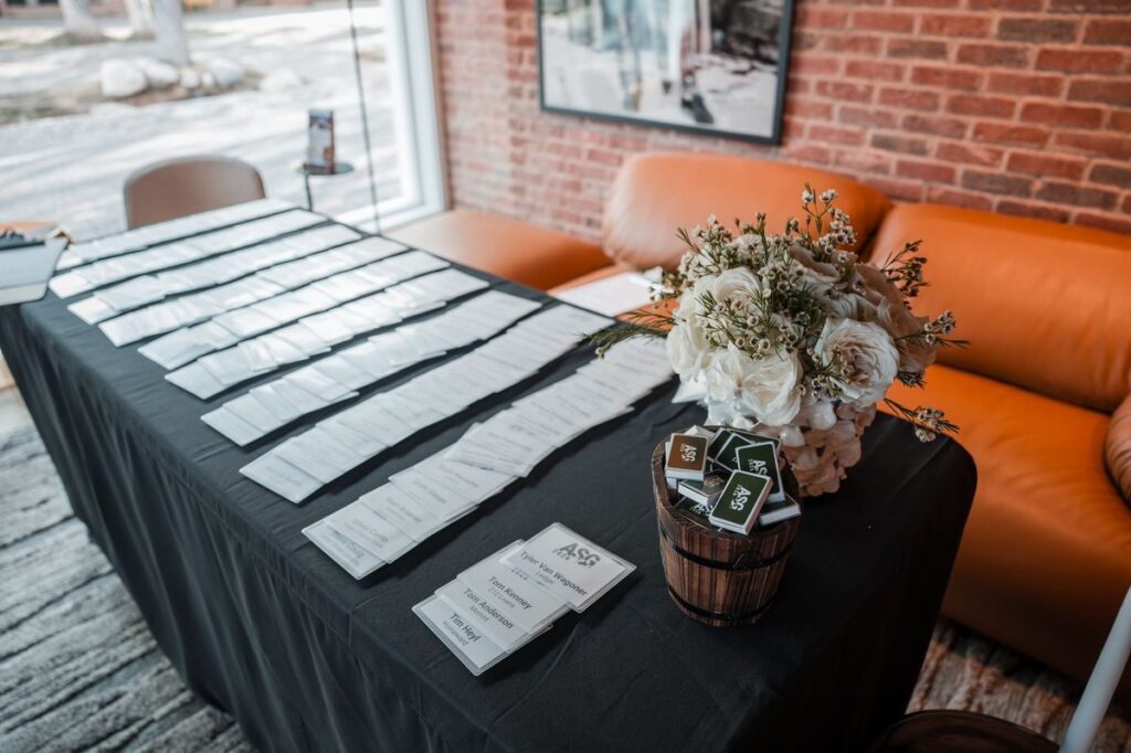 Name badges arranged beside flowers on a registration table