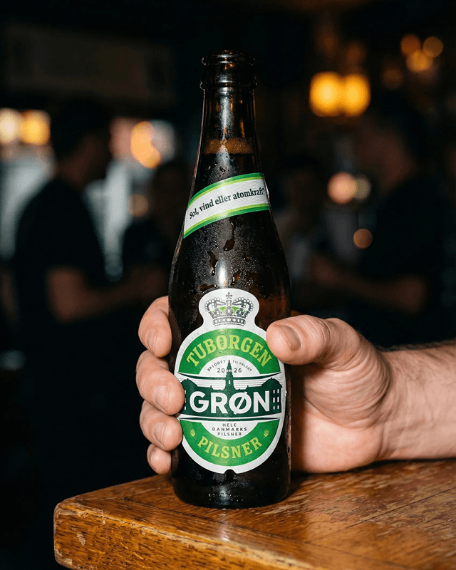 Tuborgen bottle in hand — custom label with Christiansborg Palace illustration, label design close-up