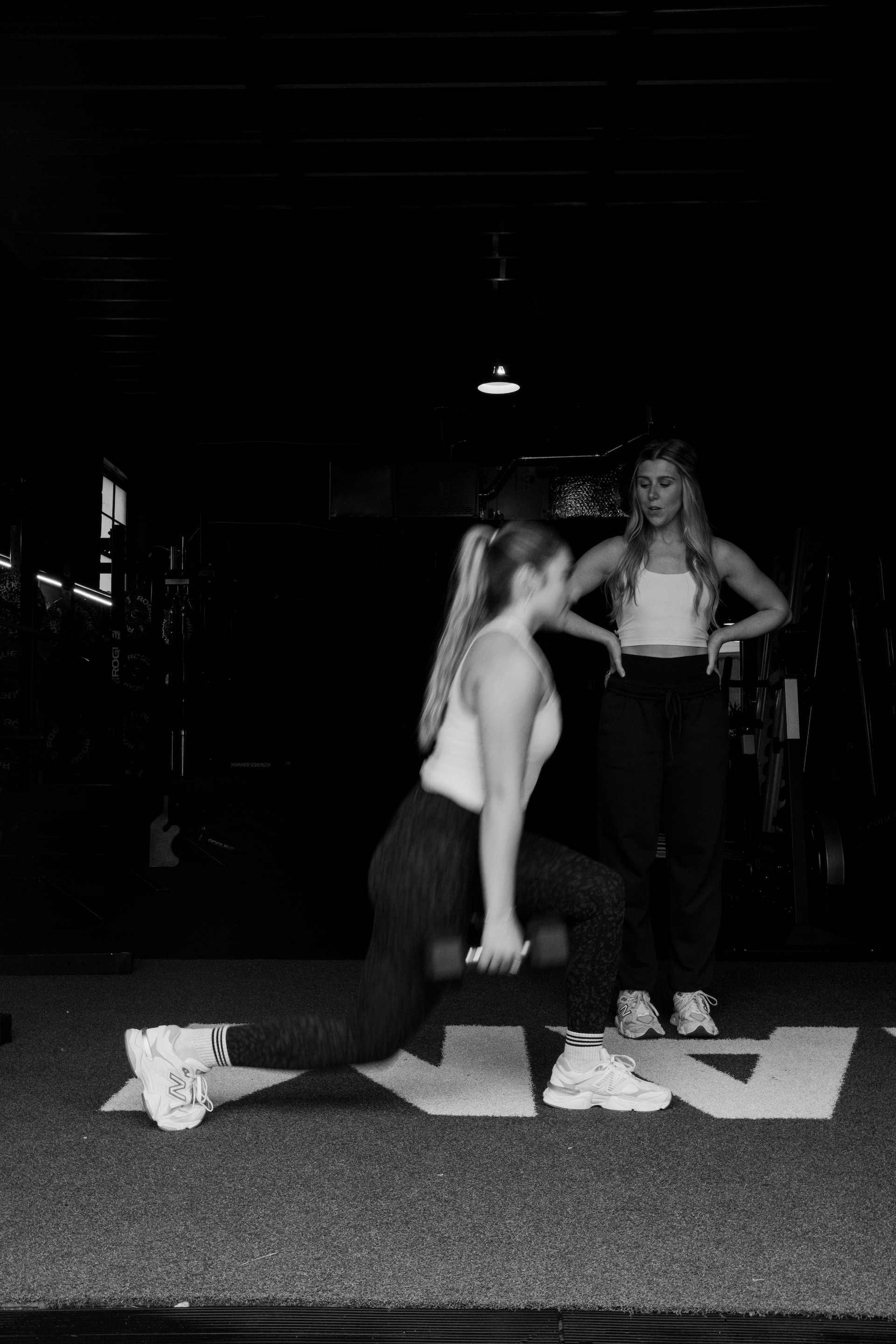 Woman coaching a fitness client on lunges