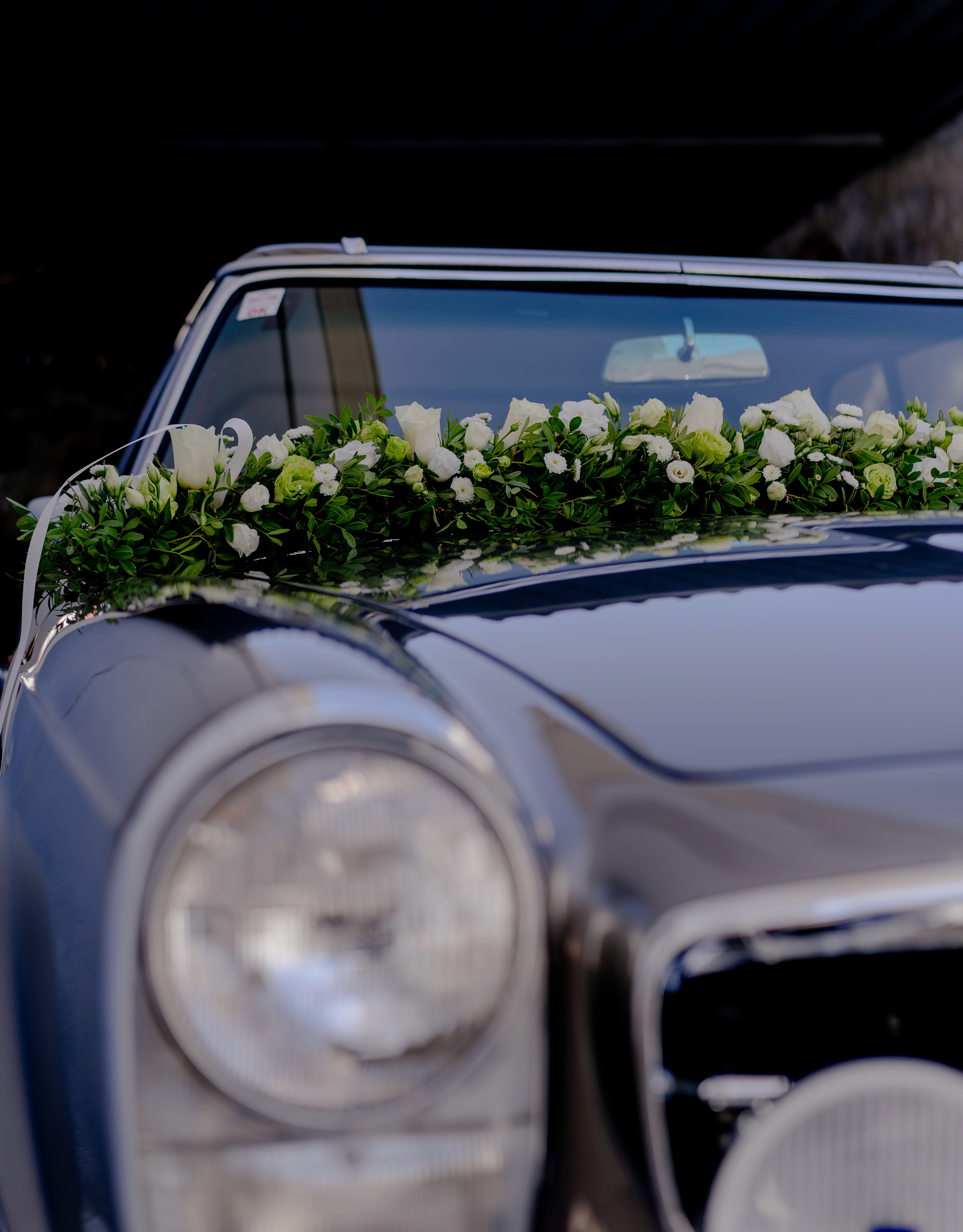 Στολισμός vintage νυφικού αυτοκινήτου με γιρλάντα από λευκά τριαντάφυλλα και πρασινάδα