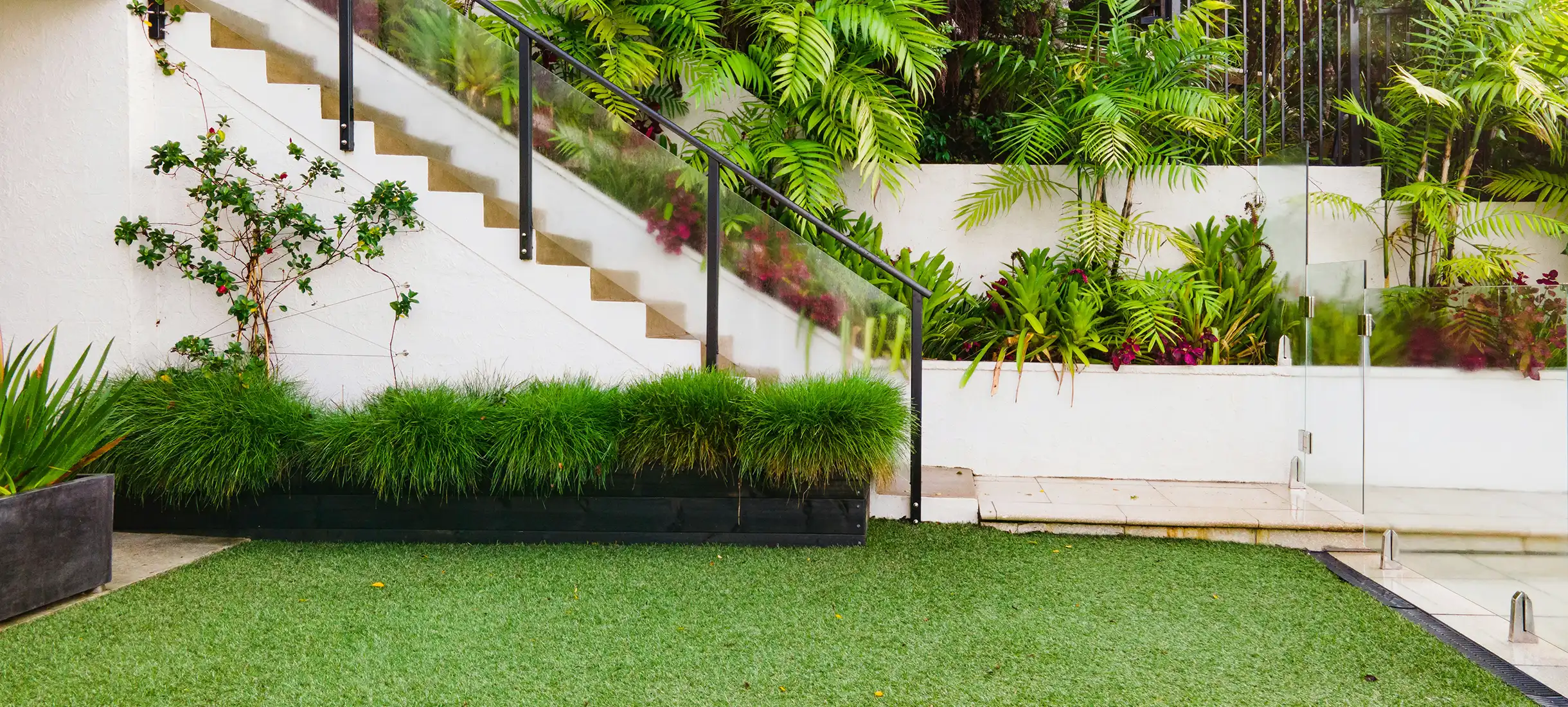 Modern house exterior with landscaped garden and paved driveway