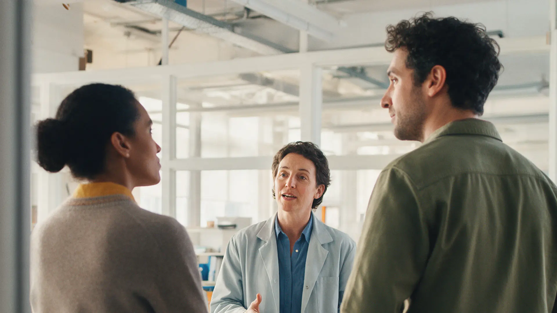Founders and a scientist discussing strategy in a laboratory