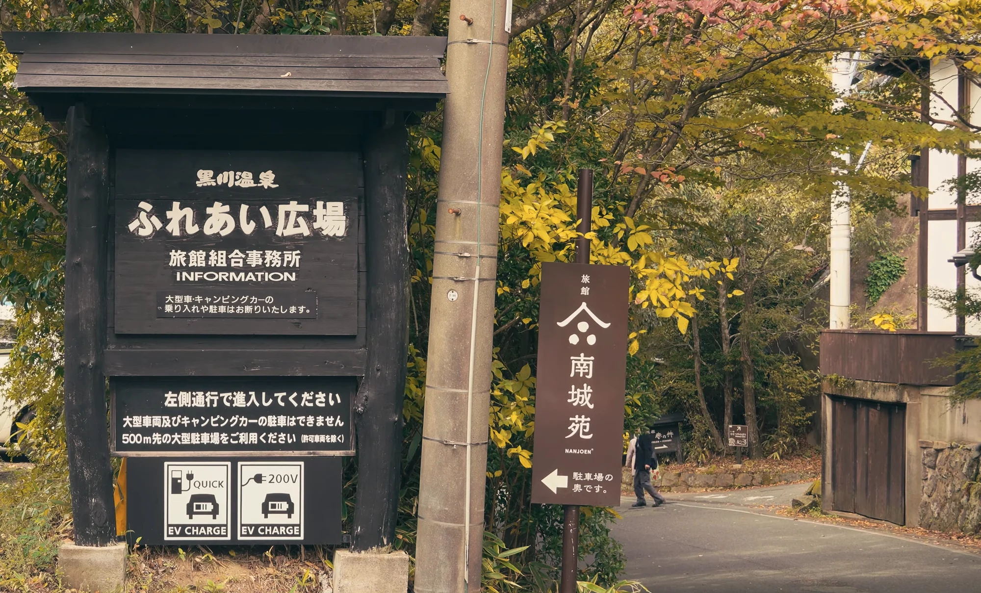 Signboard for the Kurokawa Onsen ryokan association information centre among autumn trees