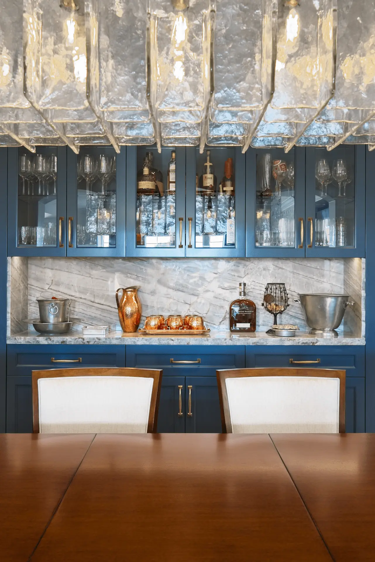Portrait overview of the bar cabinetry and countertop, with a view over the dining room table, blending functionality with entertainment in the Ladera Ranch Remodel. Photo by Todd Huge.