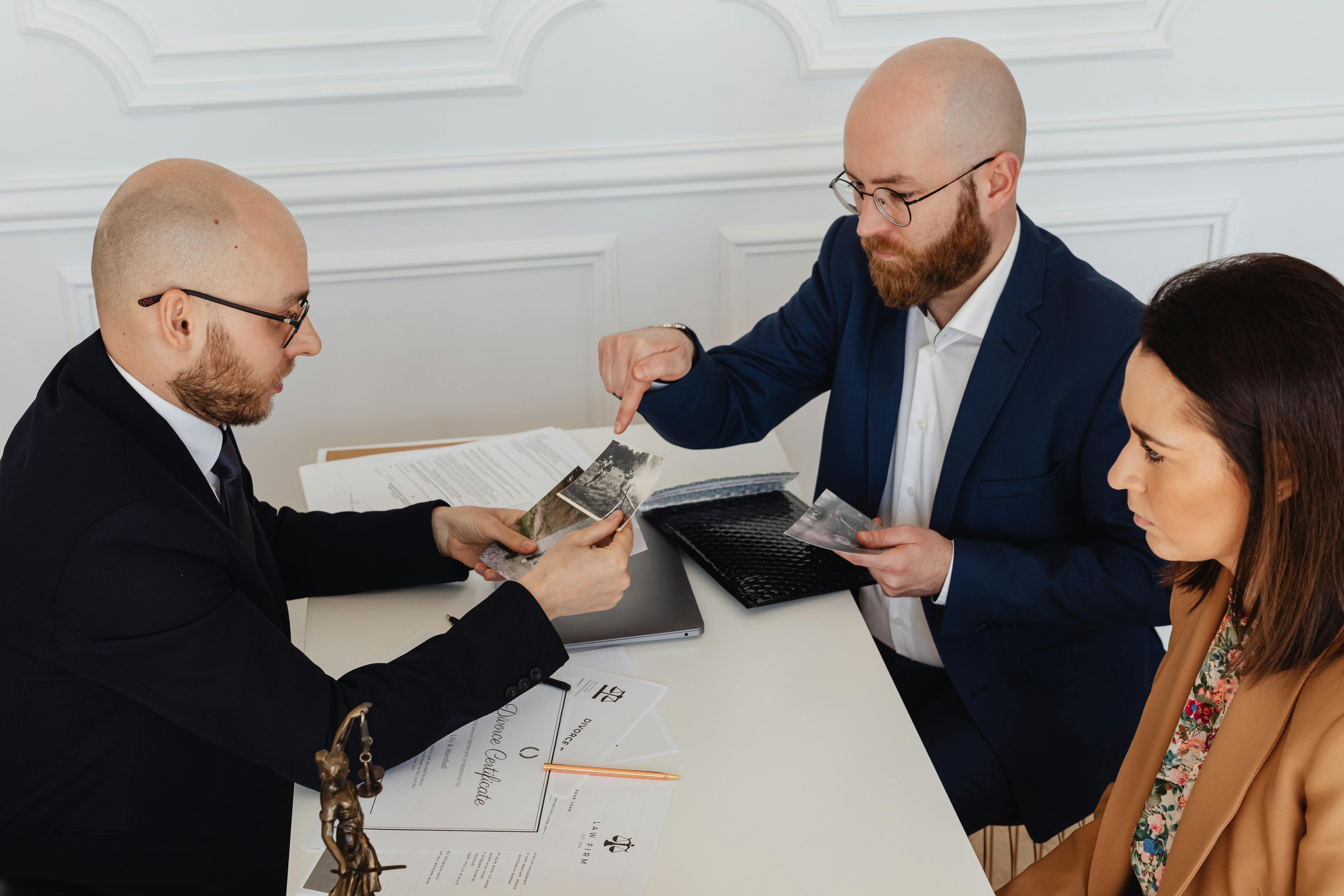 Three professionals reviewing documents at table