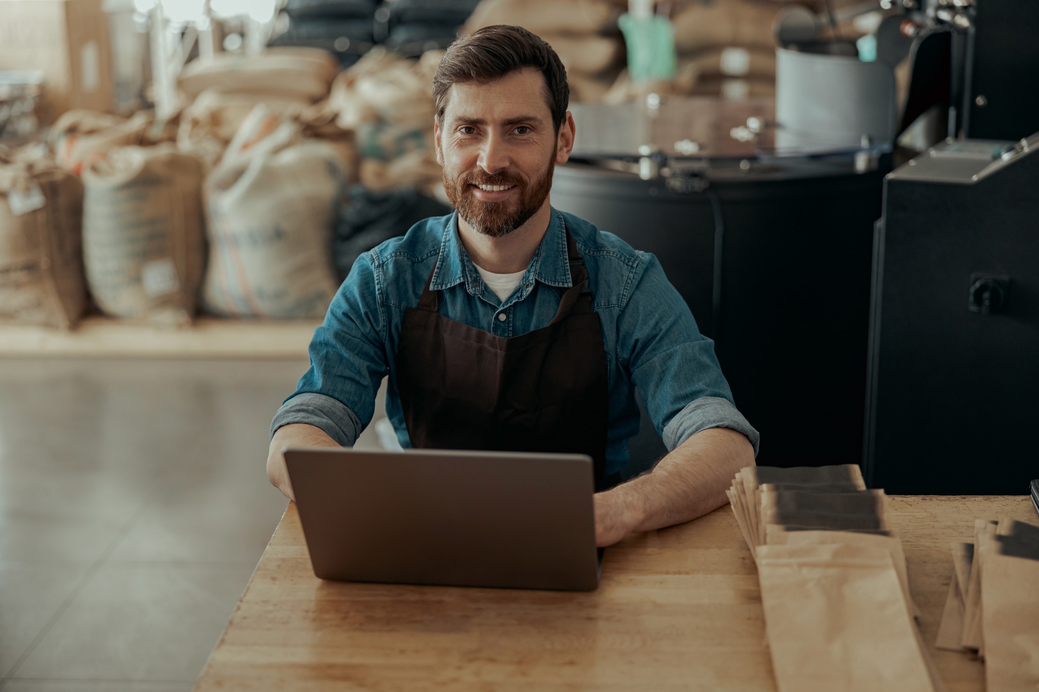 Man at desk with laptop in coffee roastery