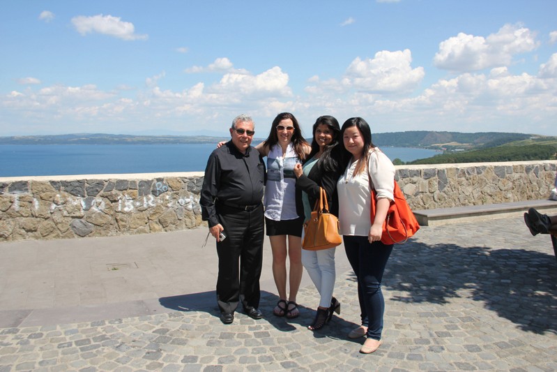 three women and a man in front of a beach