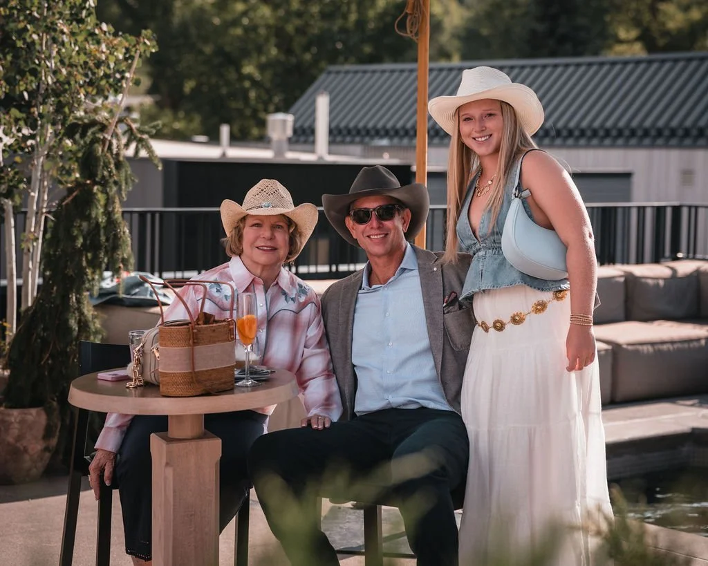 Three wedding guests relaxing at an outdoor cocktail table