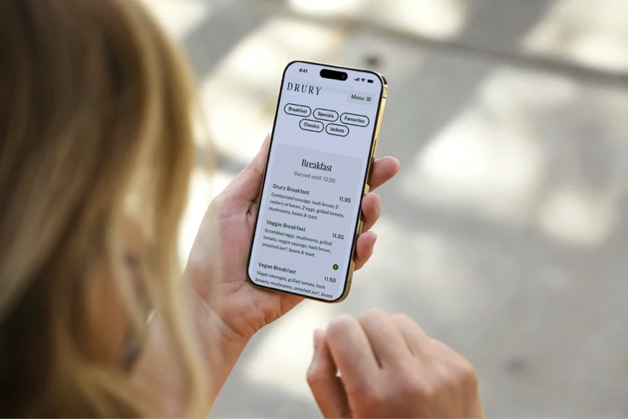 Woman outside holding phone looking at coffee website