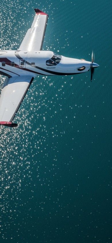 Pilatus PC-12 flying over lake