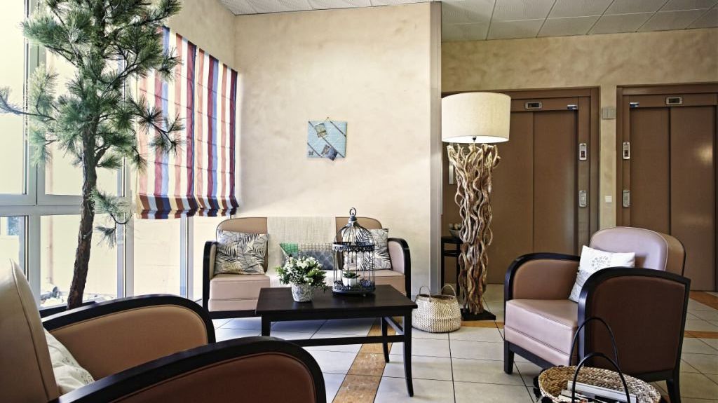 Residential interior, beige and brown common room in front of a large window