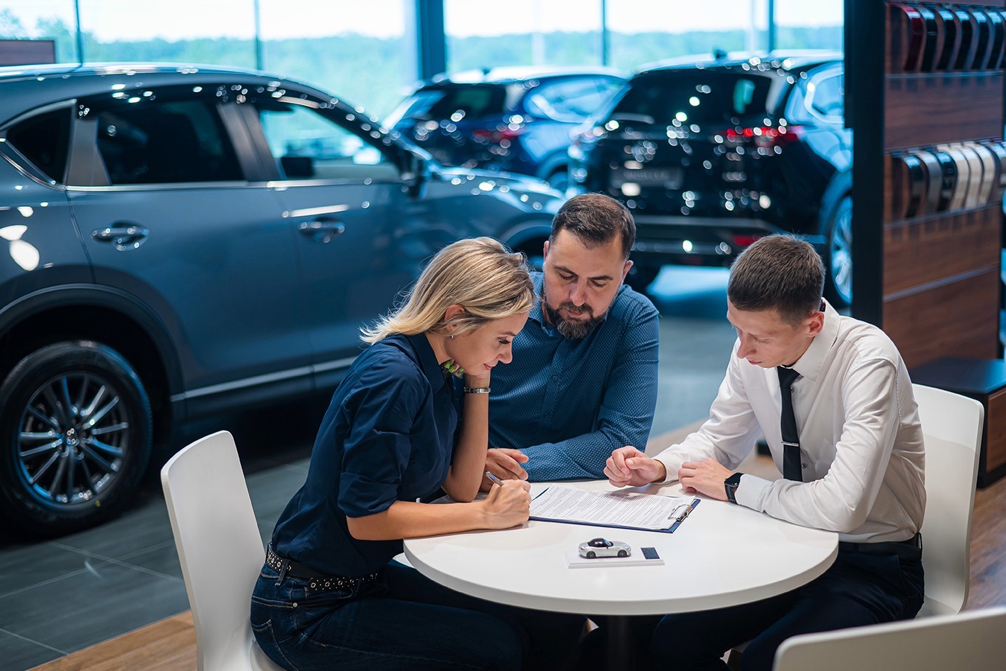 Customers discussing a vehicle purchase at a car dealership