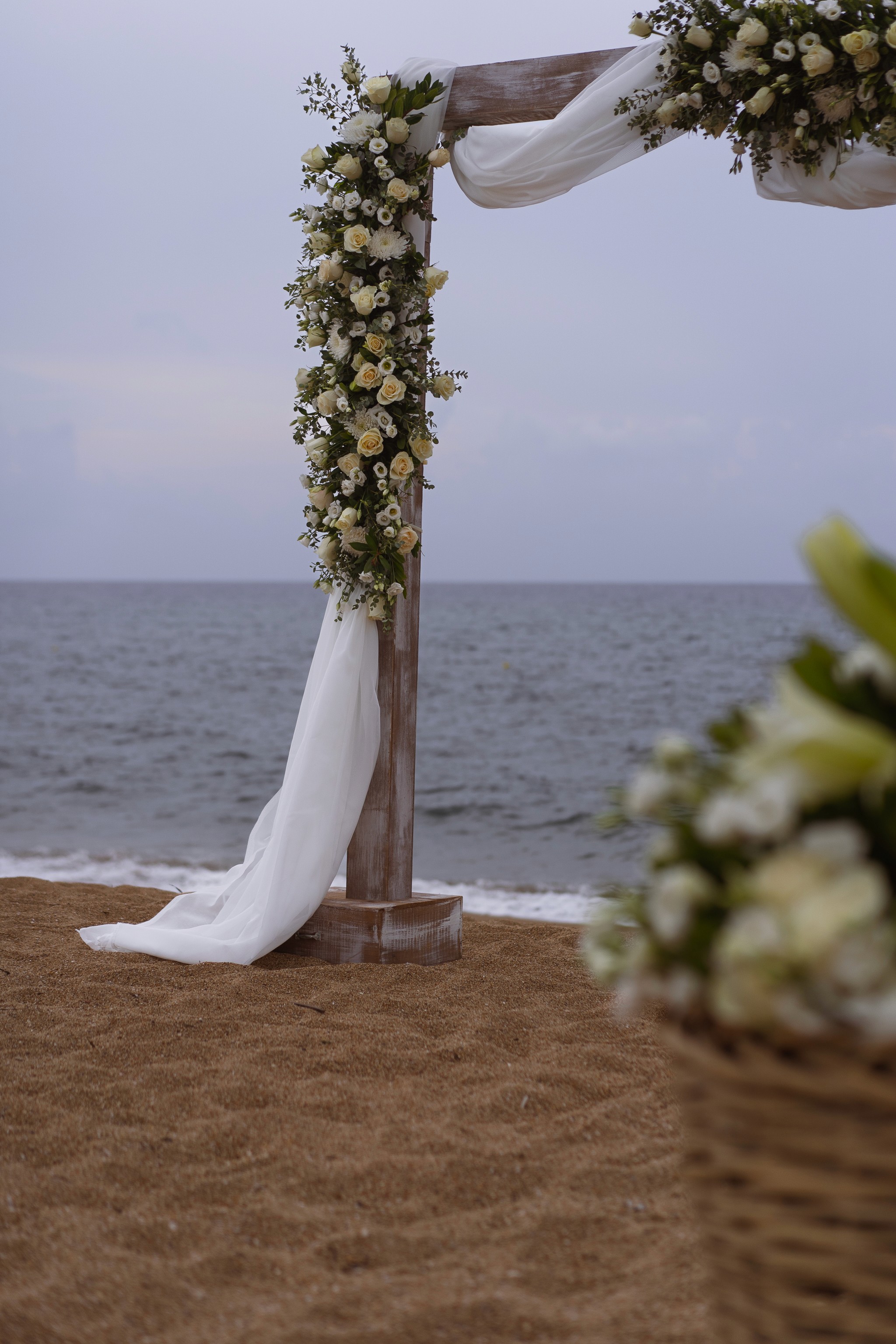 Ρομαντική αψίδα γάμου στην παραλία με λευκά τριαντάφυλλα και αέρινα υφάσματα στη Μεσσηνία