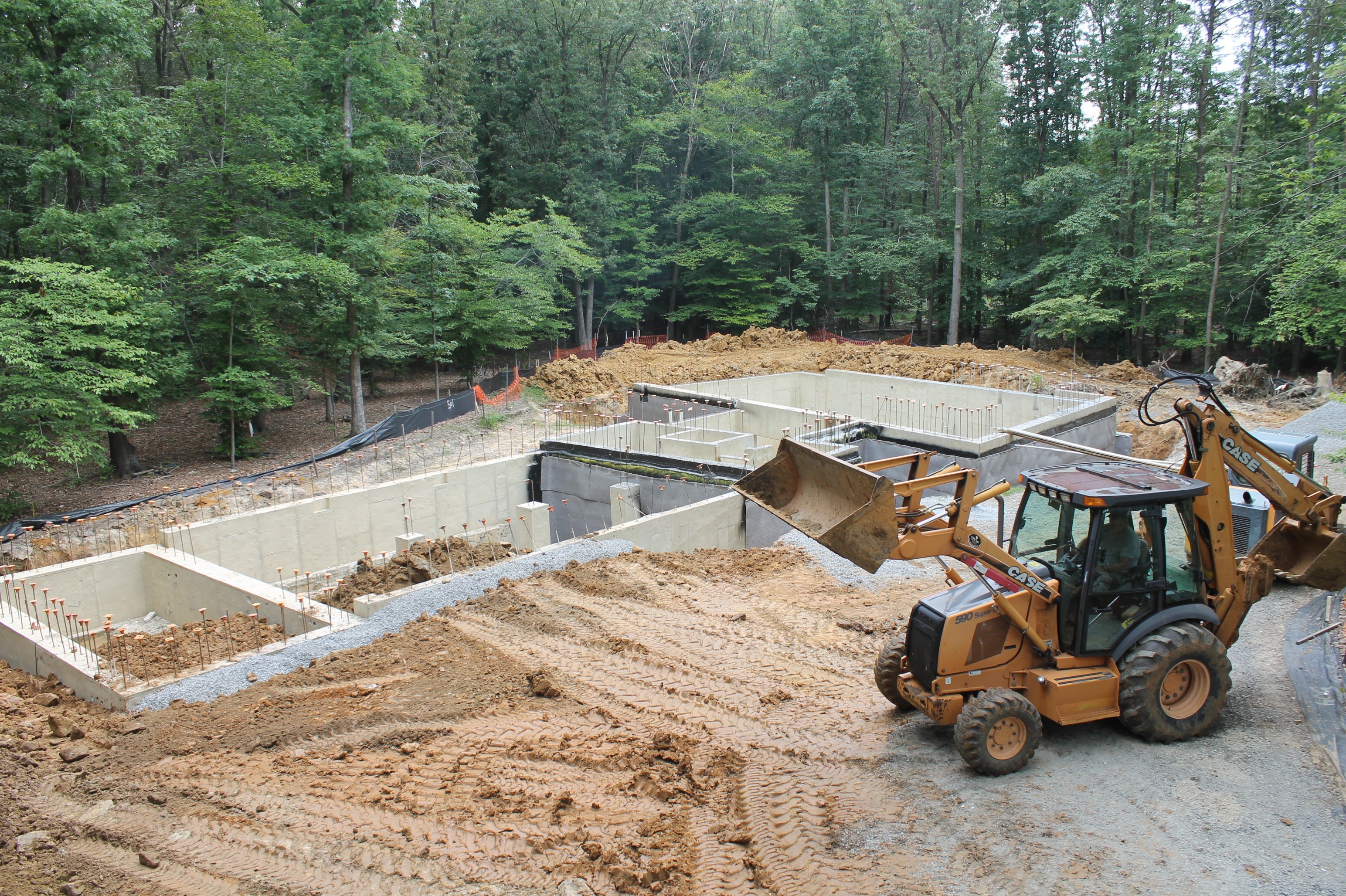 Finish grading and backfilling around a building foundation in Kansas City