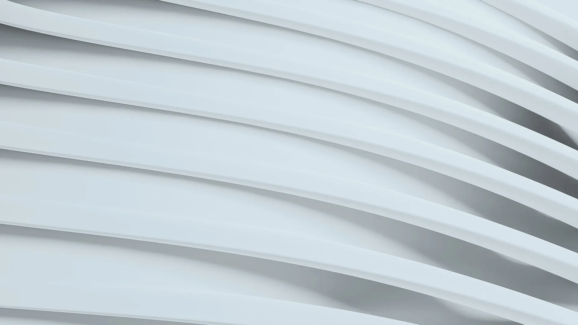 Sleek curved building with expansive glass windows, reflecting the sky and cityscape.