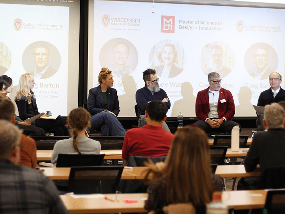 Panelists seated in front of the presentation screen