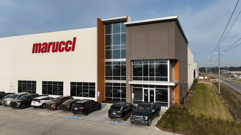 Front corner view of the Rivermark Phase I warehouse with Marucci signage and employee parking.