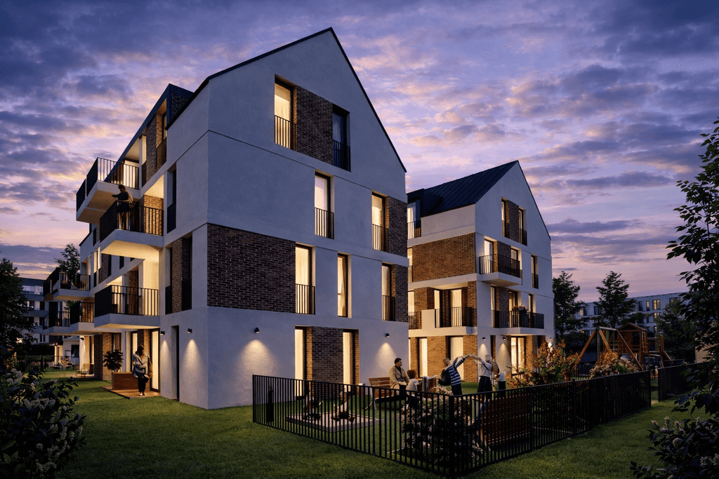 Ansicht der Fassade des Neubauprojekts bei Dämmerung, mit Lichtscheinen aus den Wohnungen und zwei Personen, die eine Wohnung durch die Gartentüre betreten.