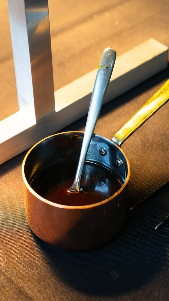 Sauce resting in a small copper pan in the evening light