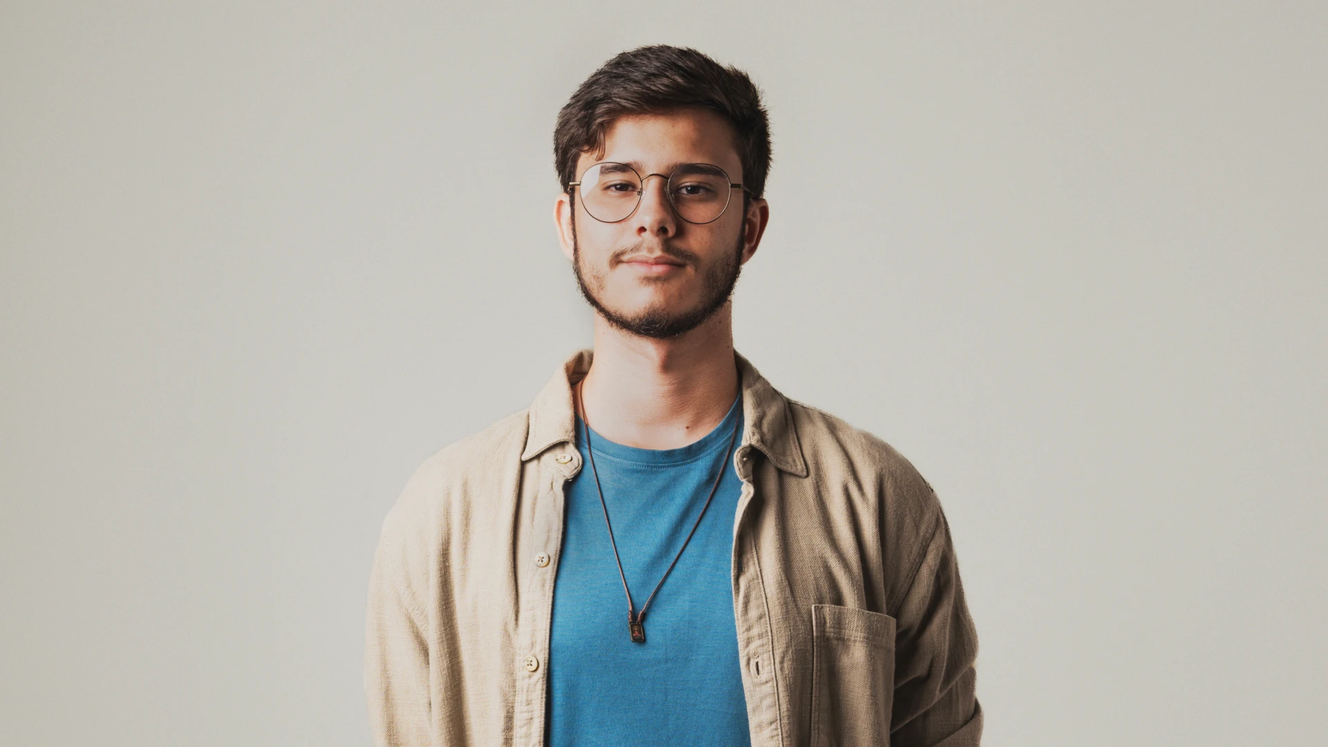 Sunlight streaming through lush green trees, casting shadows on a modern architectural building with glass panels and vertical wooden slats.