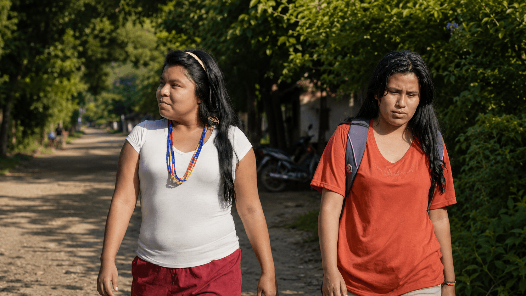 Two young U’wa women walking along a rural road as they leave their community in search of work and education.